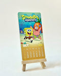 Calendar with SpongeBob SquarePants design on a stand against a white background