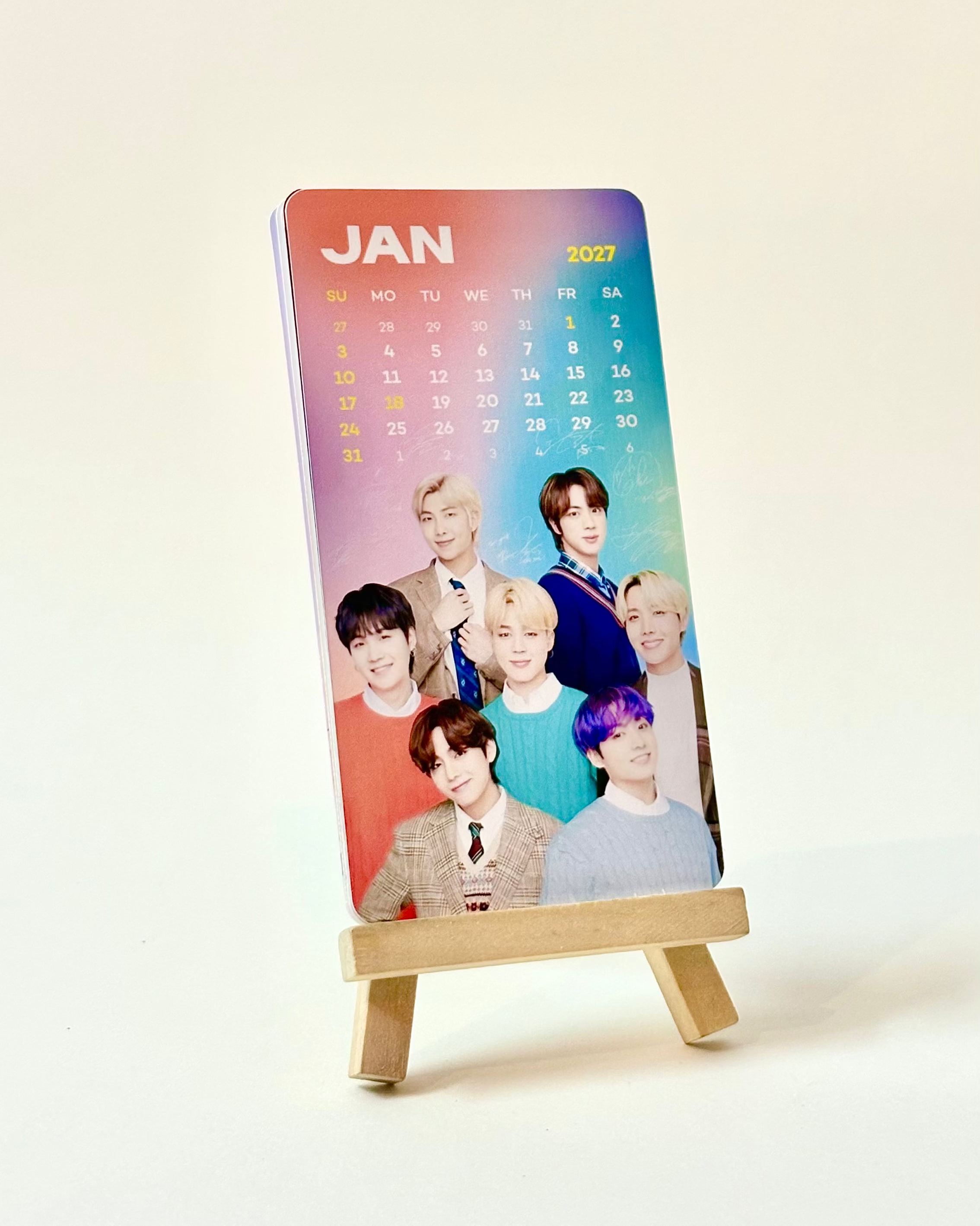 Calendar with a colorful gradient design featuring a group of people on a stand against a light background.