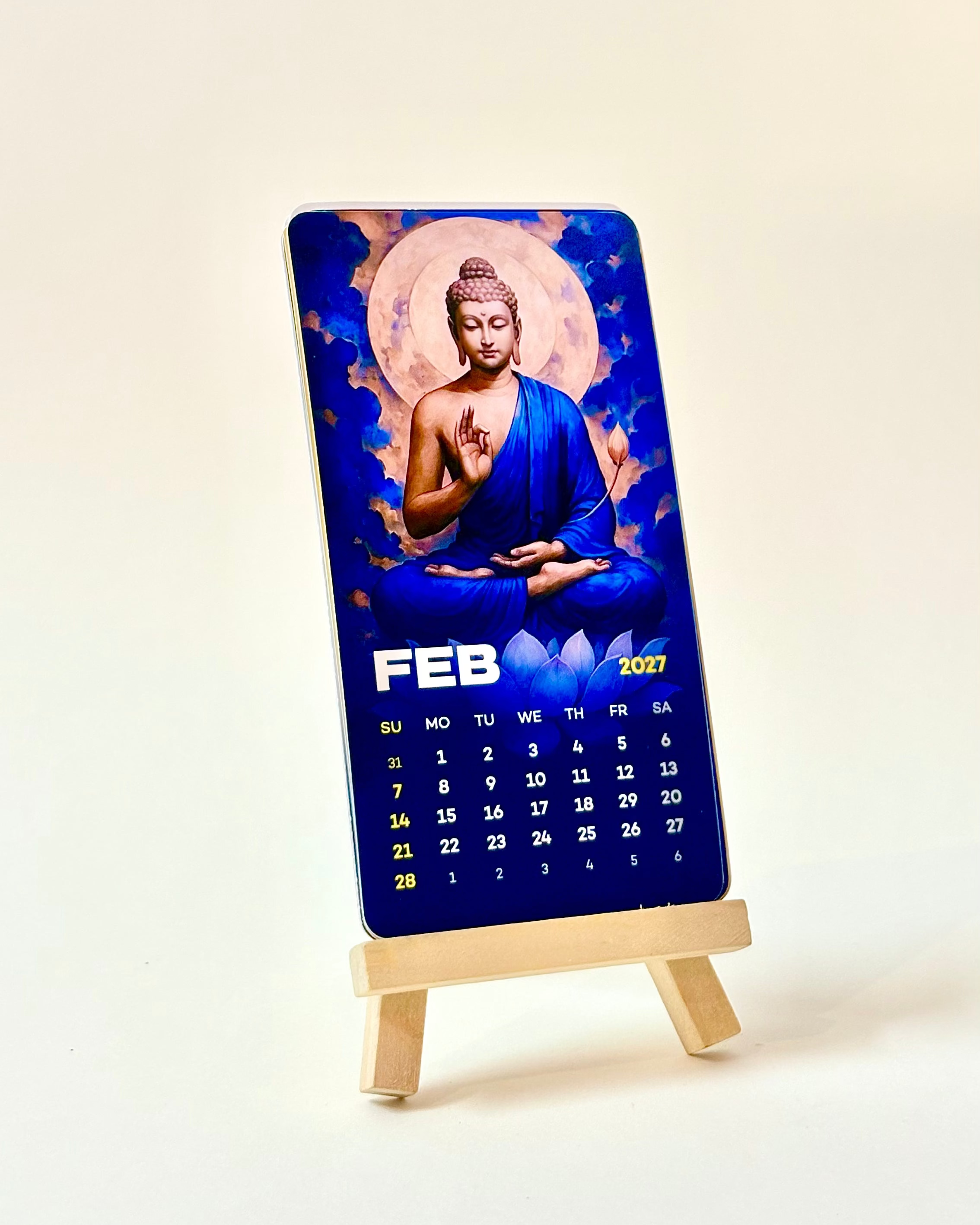 Calendar with Buddha image on a stand against a white background